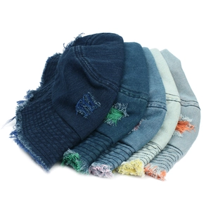 Distressed denim bucket hats with frayed edges and colorful ripped details in various blues