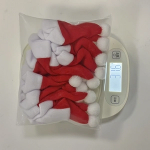 Bulk pack of mini Christmas hats for cutlery weight check showing 31.6g on scale