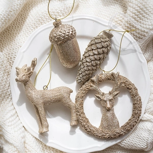 Lot de décorations de Noël dorées avec rennes et glands sur une assiette en céramique
