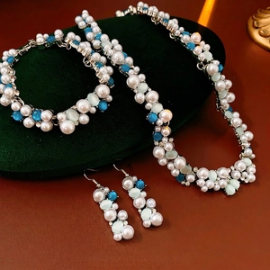 Set gioielli vintage con perle ovali e diamanti su un cuscino di velluto verde