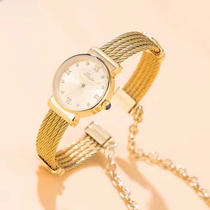 Detail of gold quartz watch with cable wire band and Roman numerals on sunray dial