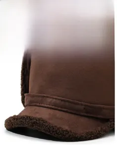 Detail of warm brown suede winter hat showing faux shearling lining and metal sports badge