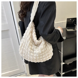 Detail of white quilted bubble texture on a large capacity shoulder hobo tote bag