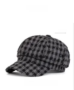 Dettaglio dei bordi sfrangiati e della trama scozzese su un cappello vintage