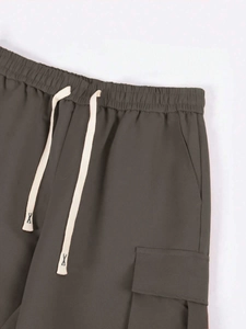 Dettaglio dell'elastico in vita con coulisse a contrasto e tasca cargo su pantaloni tecnici