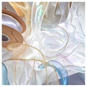 Macro detail of translucent champagne gold organza ribbon with wavy edges and fine texture