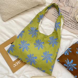 Detail of floral canvas tote bag with deep blue flower patterns and sturdy handles