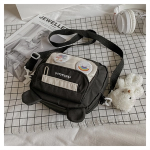 Detail of canvas crossbody bag with cartoon ear decor and adjustable black strap