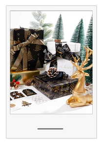 Détail du papier cadeau de Noël noir et or avec des motifs de sapins et de flocons de neige