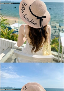 Macro detail of pink straw sun hat featuring black bow ribbon and Hello Sunshine embroidery