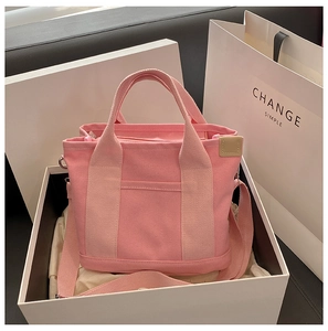 Detailed view of pink canvas tote bag showing reinforced handles and adjustable strap
