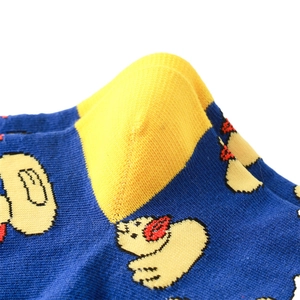 Détail du motif d'ours tricoté et du talon jaune sur des chaussettes en coton bleu marine