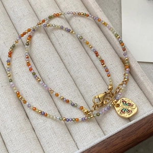 Detail shot of colorful faceted beads and golden butterfly pendant on the dainty necklace