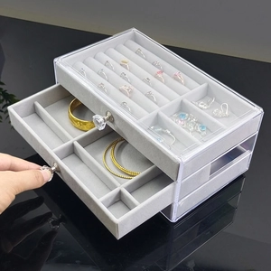 Three-tier clear acrylic jewelry organizer with grey velvet lining and ring slots