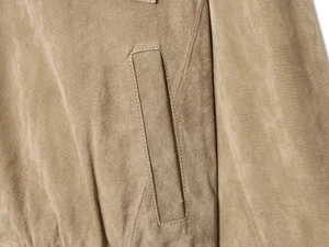 Detailaufnahme der khakifarbenen Wildlederjacke mit Präzisionsnähten und Tasche