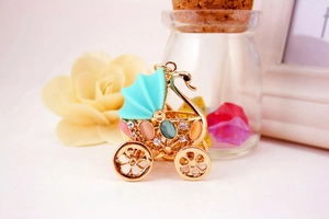 Close-up of golden swan stroller keychain with colorful gemstones and rhinestones