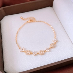Détail macro d'un bracelet fleuri plaqué or 18 carats avec oxydes de zirconium et fermoir