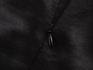 Detailed close-up of the invisible zipper on the back of this elegant black satin evening dress