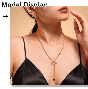 Model wearing gold flower necklace and stud earrings set with rhinestones and D charm