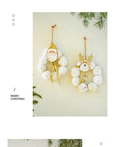 Detail of Christmas wreath with plush white balls, wooden reindeer, Santa, and gold bells