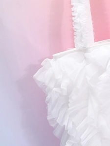 Primer plano de la textura de malla plisada de un bolso blanco estilo falda con volantes