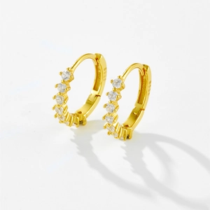 Detailed macro view of S925 sterling silver gold earrings with clear cubic zirconia stones