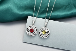 Détail de colliers tournesol avec zircons rubis rouges et jaunes et chaînes en argent