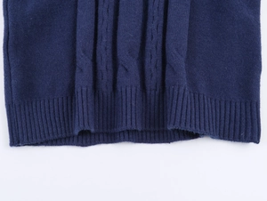 Close-up of navy blue knit polo featuring classic cable texture and ribbed hem detail