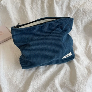 Detailed macro of blue corduroy cosmetic bag with zipper and Sozakka woven label