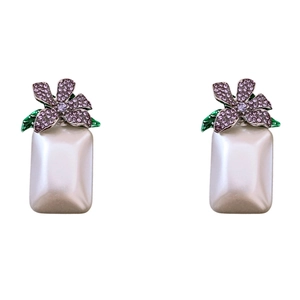 Elegante lila Strassblumen-Ohrringe mit grünem Blatt und Perlenanhänger auf weißem Grund