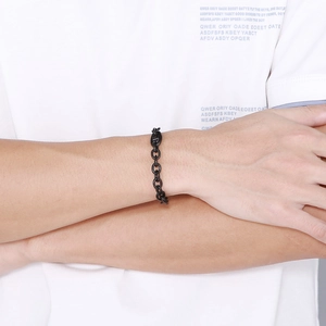 Close-up of black stainless steel pig nose chain bracelet worn on a wrist in a lifestyle view