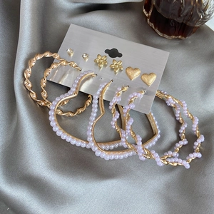 Set of 6 gold heart and pearl earrings including studs and large hoops on silk
