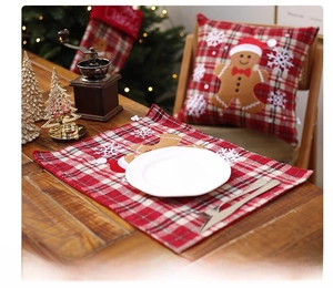 Close-up of a festive red plaid Christmas placemat featuring gingerbread man and snowflake