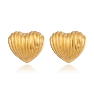 Macro shot of gold heart-shaped stud earrings with vintage vertical ribbed metal texture