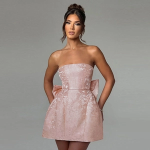 Détail de la mini-robe en jacquard rose élégante avec grands nœuds latéraux et fleurs