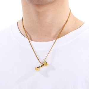 Detailansicht einer goldenen Hantel-Halskette an einem männlichen Modell für Fitness-Stil