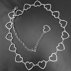 Dettaglio delle maglie a cuore cavo della catena da vita in metallo argento con estensione