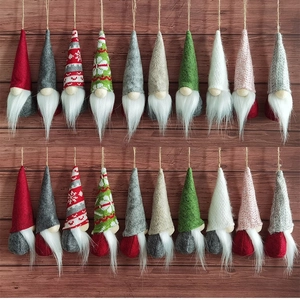 Set of 20 festive Christmas gnome plush ornaments in assorted colors on wooden background
