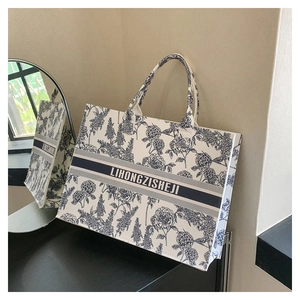 Detail of blue floral porcelain pattern on white felt tote bag with striped handle