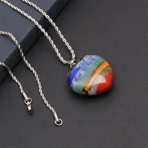 Macro shot of heart-shaped multi-color natural crystal stone pendant on silver rope chain