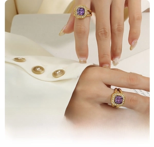 Detail of 18k gold plated titanium ring featuring a square purple zircon on a model's hand