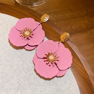Boucles d'oreilles fleurs roses mates avec perle et finition en métal doré martelé