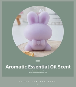 Lavender rabbit scented candle with a bow detail on a wooden base with dried orange