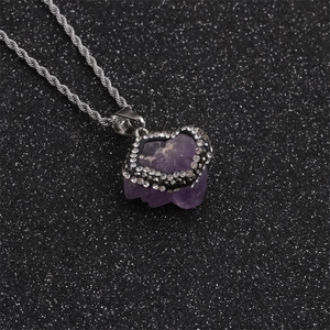 Macro shot of irregular amethyst pendant with rhinestone edges on silver twisted chain