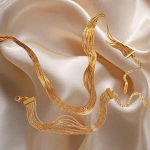 Elegant multilayered gold stainless steel tassel bracelet on silk background