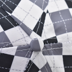 Close-up detail of checkered baseball cap crown with stitched top button and fabric texture