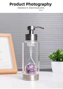 Macro shot of refillable glass soap dispenser with purple crystal stones and steel pump