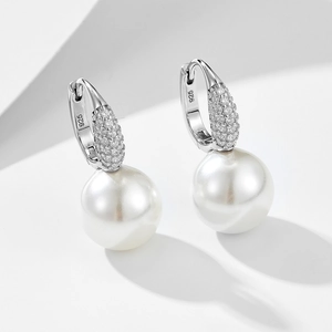 Detailed macro of 925 sterling silver huggie earring with micro-pave crystals and pearl