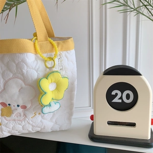 Detailed embroidery of a cartoon rabbit and sun flower charm on a quilted white tote bag