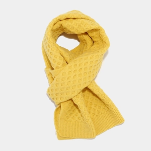 Close-up of bright yellow waffle knit scarf showing thick textured stitching details